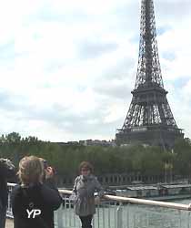 des touristes se font photographier devant la Tour Eiffel